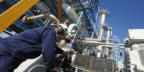 Engineer working inside large oil and gas refinery, chemical plant