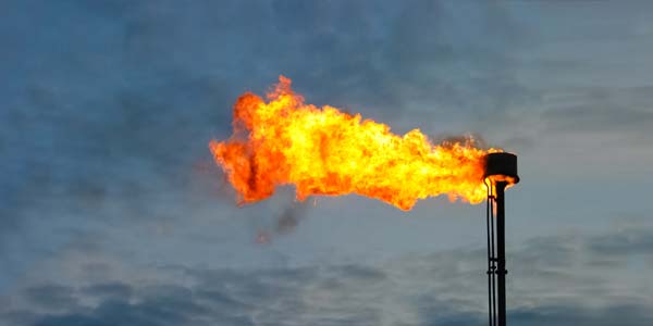 Stack flare burning off flammable gas at industrial plant